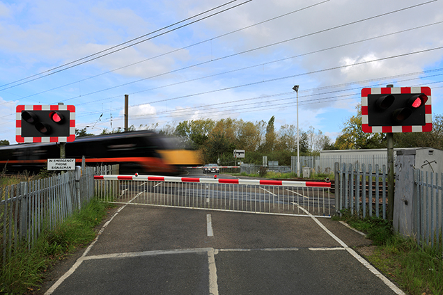 Overhead Line equipment and a fast moving train with signals at a crossing