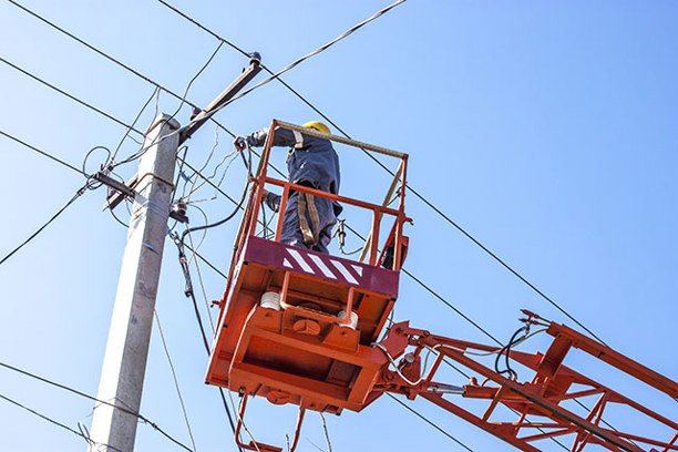 Worker on a forklift repairing the grid infrastructure