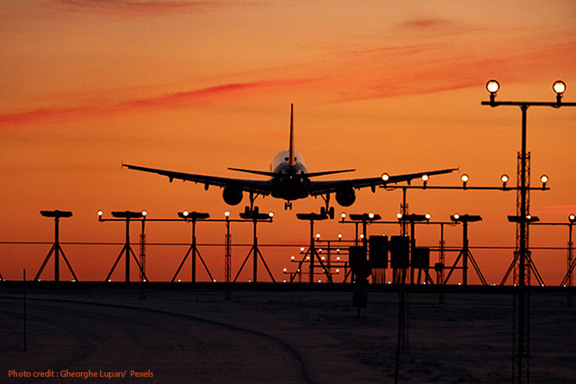 A plane landing at dusk guided by airfield lighting